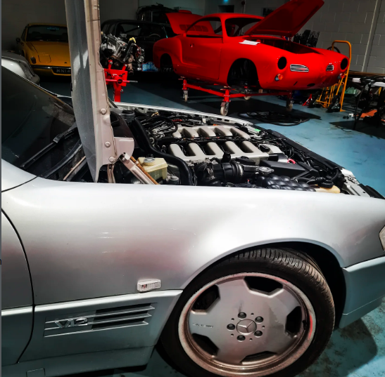 Red car on lift with Mercedes engine bay
